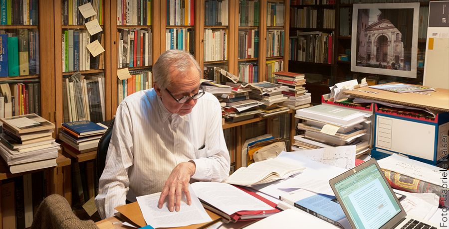 Architekt Hermann Czech mit Büchern und Laptop